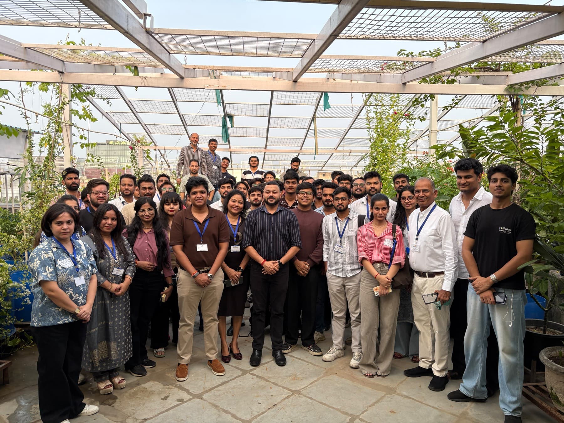 Around thirty founders standing together under a rooftop greenhouse after a meetup.